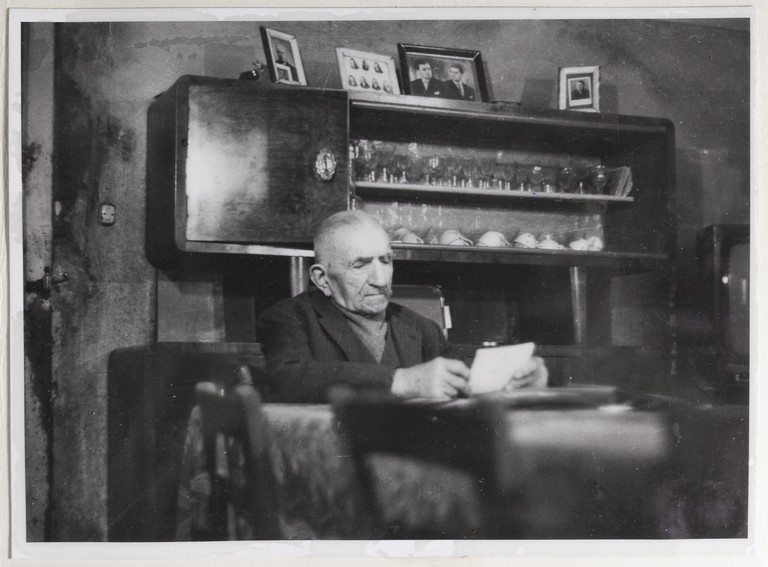 Gattatico-Reggio Emilia, 27-30 marzo 1970, Funerali di Alcide Cervi, Alcide Cervi seduto al tavolo nella sua casa con le foto dei figli